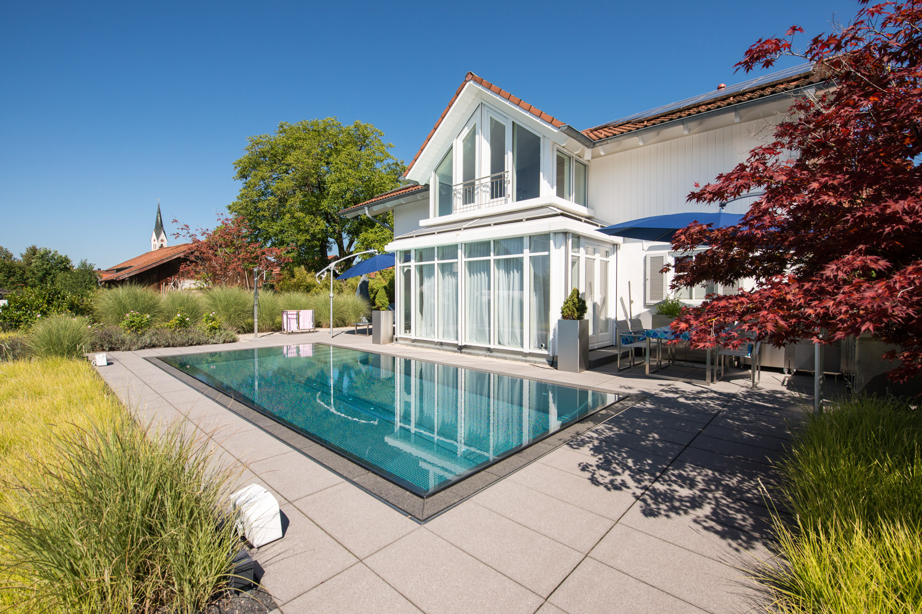 Offene Terrassenlandschaft mit Edelstahlpool