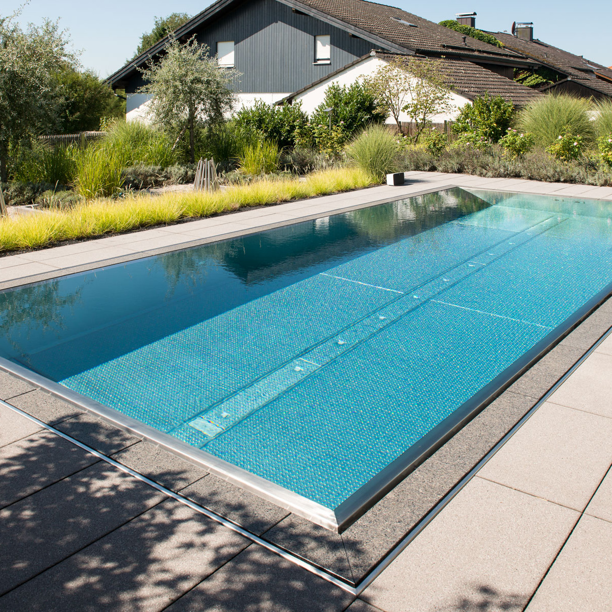 Ziergäser rahmen die Terrasse mit Pool.